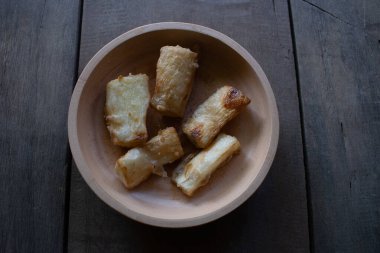 Fried cassava food served on a wooden bowl