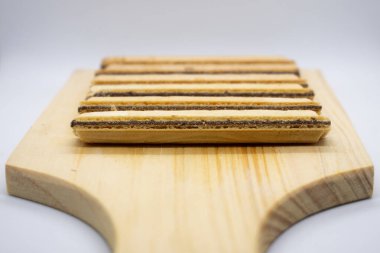 Tahta bir bardak altlığında gofret çubuğu atıştırması.