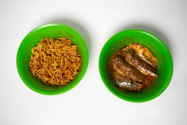 Green plastic bowl filled with sardines and fried noodles. The background is white. clipart