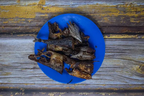 Kızarmış balık parçaları mavi bir tabakta sergileniyor. Lezzetli bir yemek olarak sunulmaya hazır.