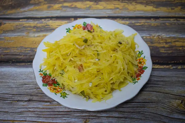 Sarı papaya kızartması, özenle baharatlı ve güzel bir çiçek tabağında sunuluyor..