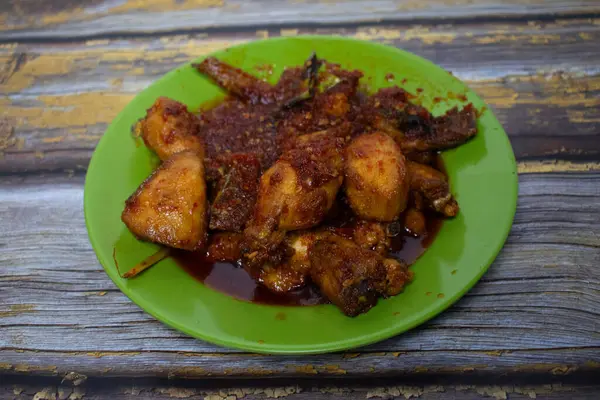 Kalın kırmızı soslu taze servis edilmiş lezzetli bir acılı tavuk yemeği..