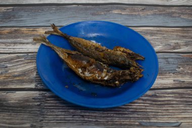 Açık mavi tabakta çıtır çıtır kızarmış balık. Lezzetli yemekler servis etmek için mükemmel..