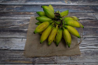Çuval bezi kumaşında hazırlanmış olgun muzlar doğal tazelik sergiliyor.