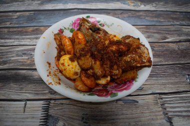 Lezzetli bir yemek, karides, yumurta, balık ve baharatlı kırmızı biber soslu tempeh..