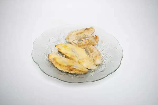 Temiz cam tabakta servis edilen kızarmış muz dilimleri.