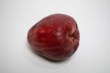 Koyu kırmızı derili tropik Jamaika guava meyveleri temiz beyaz bir yüzey üzerinde izole bir şekilde yatıyor..