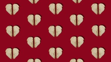 Pattern stop motion made with pieces of homemade bread on bright red background. Slices of bread in a shape of a heart. Bold food concept animation.