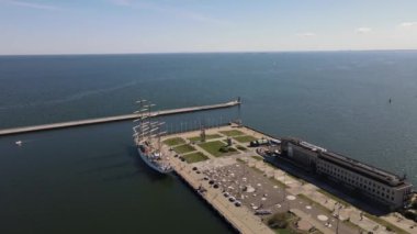 Güneşli bir yaz gününde Gdynia Limanı 'nın hava manzarası, dalgakıran ve rıhtımdaki yelkenli gemi..