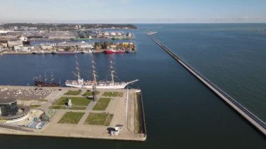 Güneşli bir yaz gününde Gdynia Limanı 'nın hava manzarası, dalgakıran ve rıhtımdaki yelkenli gemi..