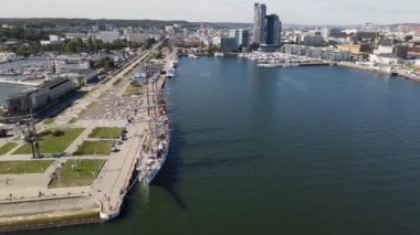 Güneşli bir yaz gününde Gdynia Limanı 'nın hava manzarası, dalgakıran ve rıhtımdaki yelkenli gemi..