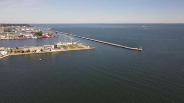 Güneşli bir yaz gününde Gdynia Limanı 'nın hava manzarası, dalgakıran ve rıhtımdaki yelkenli gemi..