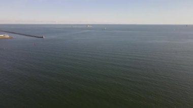 Güneşli bir sonbahar gününde Gdynia limanındaki Baltık Denizi üzerindeki dalgakıran manzarası.