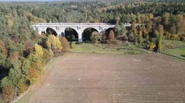 Stanczyki 'deki eski köprünün havadan görünüşü güneşli bir sonbahar gününde Suwalki bölgesinin ormanları ve tarlaları arasında..