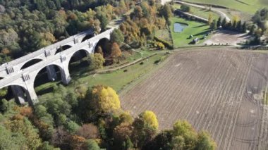 Stanczyki 'deki eski köprünün havadan görünüşü güneşli bir sonbahar gününde Suwalki bölgesinin ormanları ve tarlaları arasında..