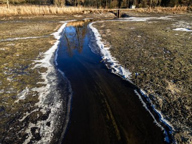 Suyu çekilmiş balık göletinin havadan görünüşü ve güneşli bir kış gününde akan bir nehir..