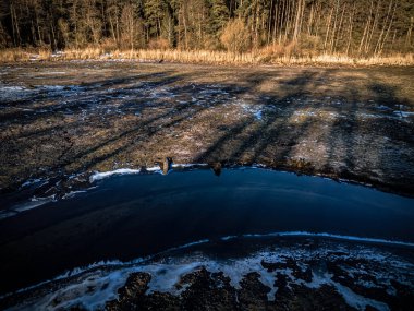 Suyu çekilmiş balık göletinin havadan görünüşü ve güneşli bir kış gününde akan bir nehir..