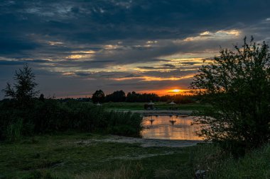 Podlasie, Nowodworce 'deki Suprasl Nehri' nin kıyısında gün batımı.