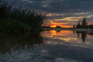 Podlasie, Nowodworce 'deki Suprasl Nehri' nin kıyısında gün batımı.