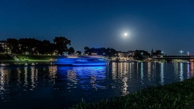 Dolunayda Krakow 'daki Vistula Nehri' nin üzerindeki gece ışıkları..