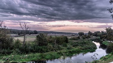 Podlasie 'deki Suprasl Nehri' ndeki bulvarlarda bulutlu bir sonbahar gününde gün doğumu..
