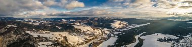 Panorama, güneşli bir kış gününde Beskid Sadecki 'deki Poprad Nehri üzerindeki Poprad Peyzaj Parkı' nın havadan görüntüsü..