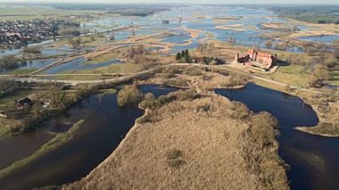 Podlasie, Tykocin 'deki Rönesans Şatosu güneşli bir bahar gününde Narew Nehri' nin arka planına karşı..