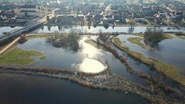 Tykocin 'deki Narew Nehri üzerinde bir köprü ve güneşli bir bahar gününde nehrin durgun suları..