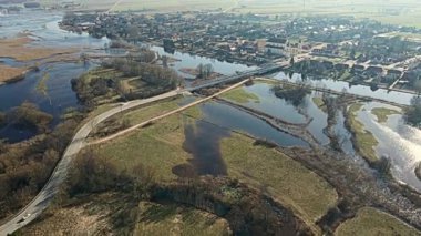 Tykocin 'deki Narew Nehri üzerinde bir köprü ve güneşli bir bahar gününde nehrin durgun suları..