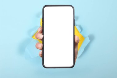 Beyaz ekranlı akıllı telefon, kameraya yakın cihazın mavi kağıt levhayı kırdığını gösteriyor.