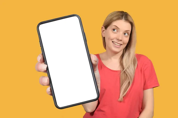 stock image App Ad. Smiling pretty woman holding smartphone with white blank device screen in hand close up to camera