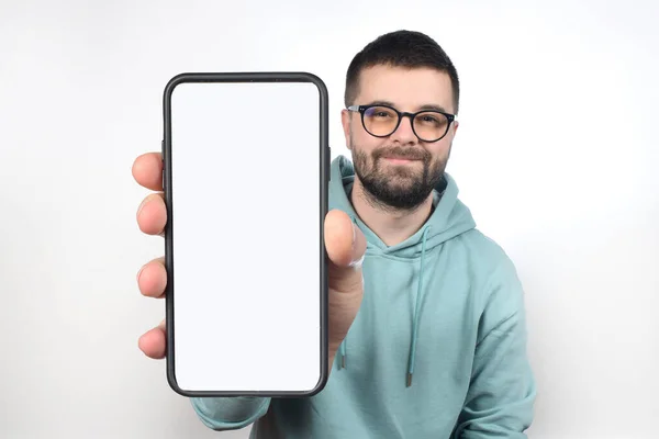陽気な感情的な男は白い画面を示す手で大きな空白の携帯電話を保持 — ストック写真