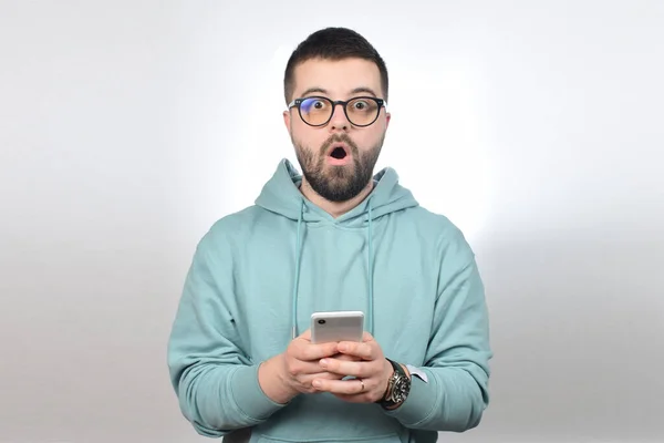 Förvånad Ung Man Glasögon Håller Telefonen — Stockfoto