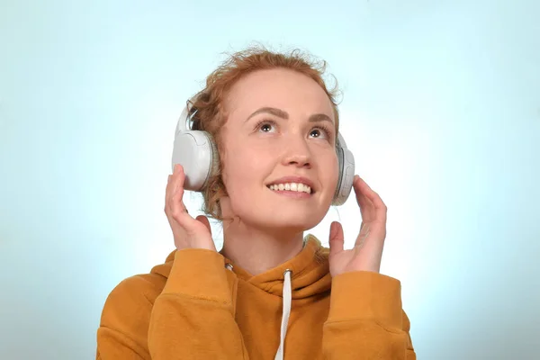 可爱的红头发卷曲女人喜欢耳机里的音乐 — 图库照片