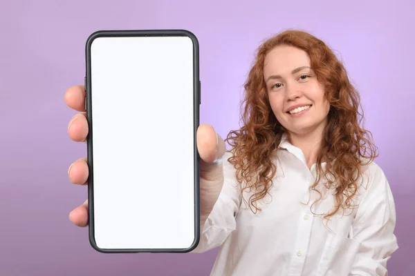 白い画面で携帯電話を持っているかわいい赤髪の若い女性 — ストック写真