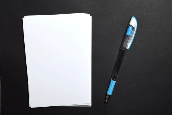 黒い表面に青いペンと白い紙 — ストック写真