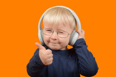 Gözlüklü sevimli çocuk başparmağını kaldırıyor.