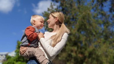 Kollarında bir çocukla mutlu bir anne.