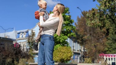 Kollarında bir çocukla mutlu bir anne.