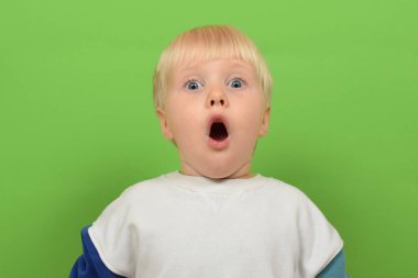 Renkli arka planda şirin bir çocuk. Şok olmuş çocuk renk arkaplanında