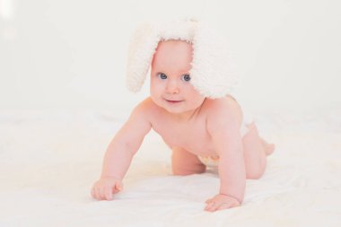 Beyaz arka planda tavşan kulaklı şirin bir bebek. Yeni doğan.