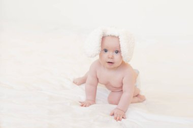Beyaz arka planda tavşan kulaklı şirin bir bebek. Yeni doğan.