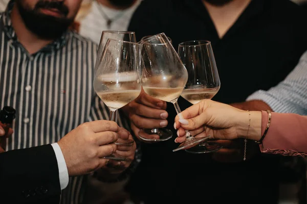 Cheers, we celebrate friendship with a glass of wine with friends and loved ones in a memorable evening.