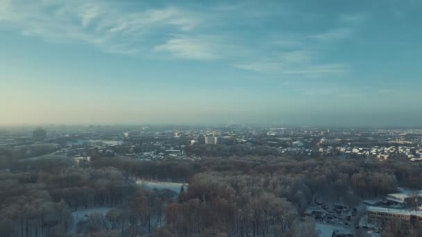 无人机在城市上空飞行阳光明媚的冬日下午公园和城市全景 无人机冬季镜头 冰雪与太阳 房屋和树木 — 图库视频影像