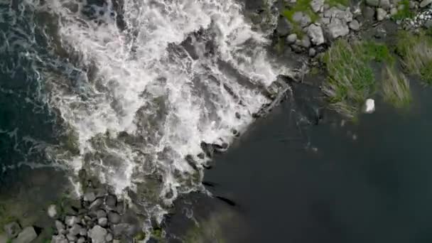 小さな滝の川の静的なトップビュー ストーンボルダースの小滝空中ドローンショットを介したストリーム実行 春には野生の川の水が噴き出しています シネマティックドローンフッテージ4K — ストック動画