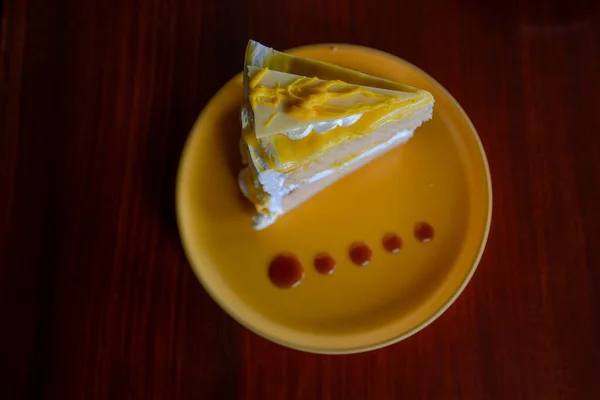 Treat of slice of lemon cake on yellow plate.