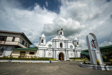 Filipinler, Ilocos Sur 'daki çarpıcı Bangar Kilisesi. Tepesinde haç olan beyaz bir kilise, bulutların üzerine kurulmuş. Bir ibadet yeri ve şehirde bir simge...
