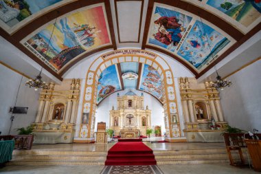 Filipinler, Ilocos Sur 'daki Bangar Kilisesi' nin içinde. Tavanı yüksek büyük bir kilise. Tavandaki resim, Kutsal Ruh 'un gücüne, Bakire Meryem' in bedenine, İsa 'nın bulunmasına ve tapınağa göndermeler içeriyor..