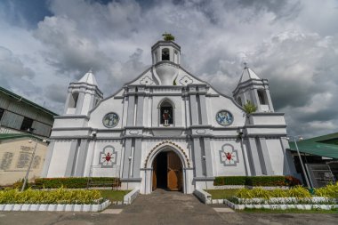 Filipinler, Ilocos Sur 'daki çarpıcı Bangar Kilisesi. Tepesinde haç olan beyaz bir kilise, bulutların üzerine kurulmuş. Bir ibadet yeri ve şehirde bir simge...