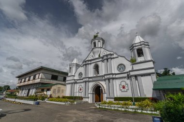 Filipinler, Ilocos Sur 'daki çarpıcı Bangar Kilisesi. Tepesinde haç olan beyaz bir kilise, bulutların üzerine kurulmuş. Bir ibadet yeri ve şehirde bir simge...